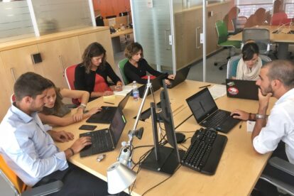 Trabajadores reunidos con ordenadores en mesa