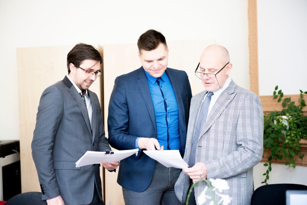 Tres hombres mirando papeles